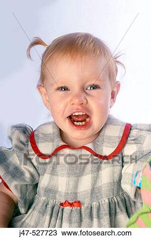 Stock Image - 3 year old girl smiling into camera. Fotosearch