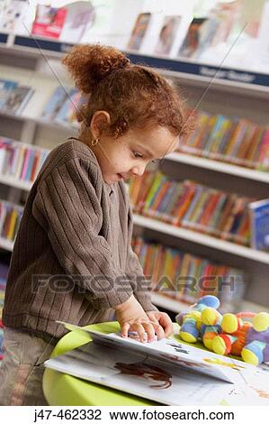 3 year old girl standing in a library looking at books View Large Photo Image Stock Image - 3 year old girl standing in a library looking at books. Fotosearch