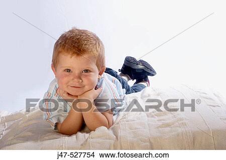 3 year old, red haired boy smiling into camera, lying on his stomach View Large Photo Image Picture - 3 year old, red haired boy smiling into camera, lying on his stomach. Fotosearch