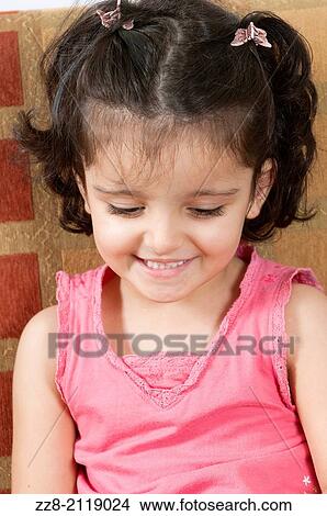 Picture - 3 years old girl smiling looking down.. Fotosearch