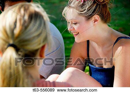 3 young adults sitting together outdoors View Large Photo Image Stock Photo - 3 young adults sitting together outdoors. Fotosearch