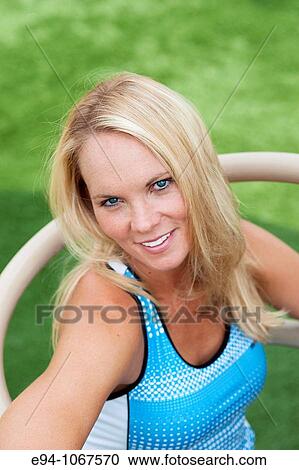 Stock Image - 30 year old blonde woman in work out clothes exercising. Fotosearch
