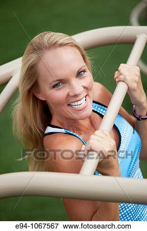 Stock Photo - 30 year old blonde woman in work out clothes exercising. Fotosearch