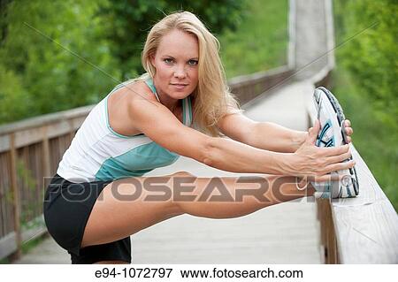 30 year old blonde woman in work out clothes stretching View Large Photo Image Stock Photo - 30 year old blonde woman in work out clothes stretching. Fotosearch