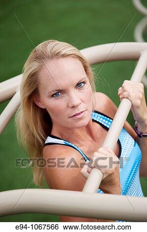 Stock Photograph - 30 year old blonde woman in work out clothes exercising. Fotosearch