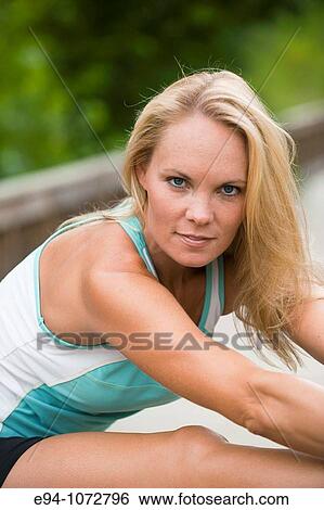 30 year old blonde woman in work out clothes stretching View Large Photo Image Stock Photograph - 30 year old blonde woman in work out clothes stretching. Fotosearch