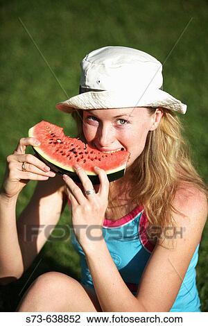 Stock Image - 30 year old woman eating watermelon.. Fotosearch