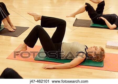 30 year old woman in a pilates class lying on her back stretching one leg, toes pointed View Large Photo Image Stock Image - 30 year old woman in a pilates class lying on her back stretching one leg, toes pointed. Fotosearch