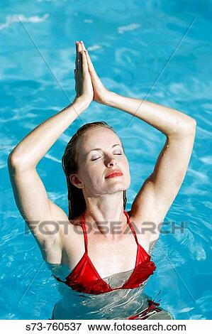 30 year old woman in meditation inside swimming pool wearing red bikini View Large Photo Image Stock Photo - 30 year old woman in meditation inside swimming pool wearing red bikini. Fotosearch