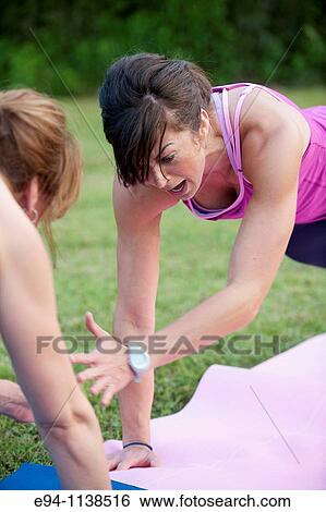 30 year old woman in work out clothing leading a boot camp demonstrating high five push ups with a partner View Large Photo Image Stock Photograph - 30 year old woman in work out clothing leading a boot camp demonstrating high five push ups with a partner. Fotosearch
