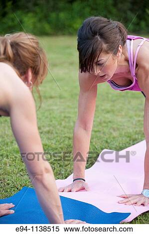30 year old woman in work out clothing leading a boot camp demonstrating high five push ups with a partner View Large Photo Image Stock Photography - 30 year old woman in work out clothing leading a boot camp demonstrating high five push ups with a partner. Fotosearch