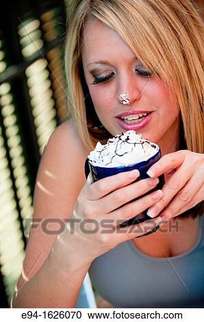 31 year old blond woman holding a coffee mug with cream on her tongue in a cafe View Large Photo Image Stock Image - 31 year old blond woman holding a coffee mug with cream on her tongue in a cafe. Fotosearch