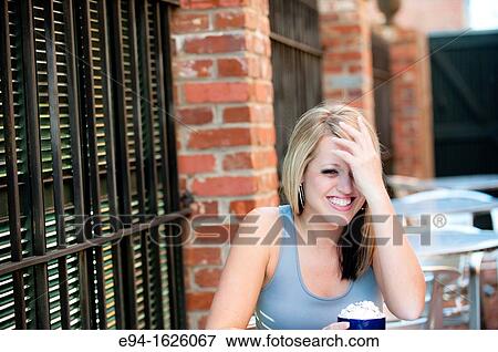 31 year old blond woman sitting in an outdoor cafe with a mug of coffee laughing looking away from the camera View Large Photo Image Stock Photo - 31 year old blond woman sitting in an outdoor cafe with a mug of coffee laughing looking away from the camera. Fotosearch