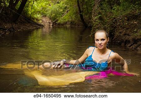 34 year old blond woman in a flower print dress sitting in the water of a small creek looking directly at the camera. View Large Photo Image Stock Photography - 34 year old blond woman in a flower print dress sitting in the water of a small creek looking directly at the camera.. Fotosearch