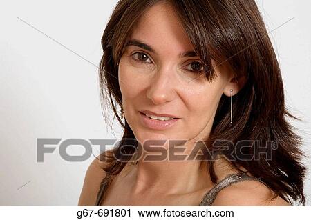 35 Year old female brunette looks into the camera as she poses for studio head shot portrait. View Large Photo Image Stock Image - 35 Year old female brunette looks into the camera as she poses for studio head shot portrait.. Fotosearch