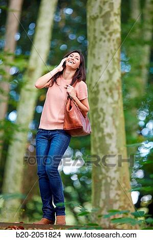 Picture - 35 year old woman in park talking with smartphone. Donostia. San Sebastian. Gipuzkoa. Basque Country- Spain.. Fotosearch