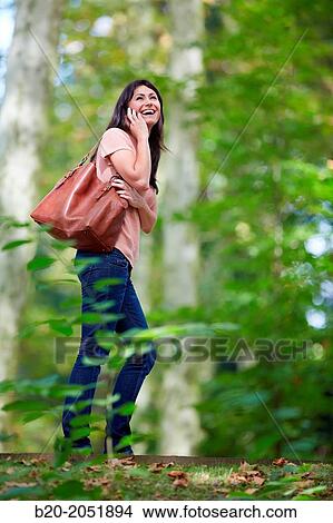 35 year old woman in park talking with smartphone. Donostia. San Sebastian. Gipuzkoa. Basque Country- Spain. View Large Photo Image Picture - 35 year old woman in park talking with smartphone. Donostia. San Sebastian. Gipuzkoa. Basque Country- Spain.. Fotosearch