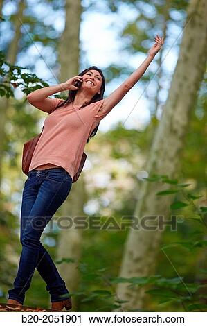 Stock Image - 35 year old woman in park talking with smartphone. Donostia. San Sebastian. Gipuzkoa. Basque Country- Spain.. Fotosearch