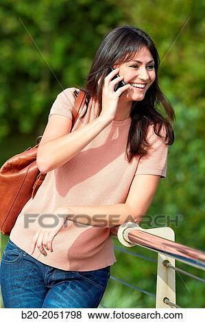 Stock Photo - 35 year old woman in park talking with smartphone. Donostia. San Sebastian. Gipuzkoa. Basque Country- Spain.. Fotosearch