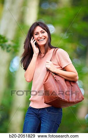 35 year old woman in park talking with smartphone. Donostia. San Sebastian. Gipuzkoa. Basque Country- Spain. View Large Photo Image Stock Photo - 35 year old woman in park talking with smartphone. Donostia. San Sebastian. Gipuzkoa. Basque Country- Spain.. Fotosearch