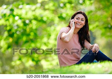 35 year old woman in park talking with smartphone. Donostia. San Sebastian. Gipuzkoa. Basque Country- Spain. View Large Photo Image Stock Photo - 35 year old woman in park talking with smartphone. Donostia. San Sebastian. Gipuzkoa. Basque Country- Spain.. Fotosearch