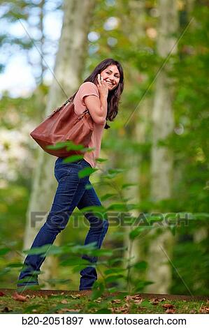 Stock Photo - 35 year old woman in park talking with smartphone. Donostia. San Sebastian. Gipuzkoa. Basque Country- Spain.. Fotosearch