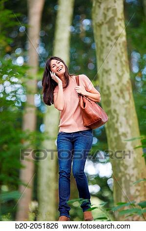 Stock Photograph - 35 year old woman in park talking with smartphone. Donostia. San Sebastian. Gipuzkoa. Basque Country- Spain.. Fotosearch