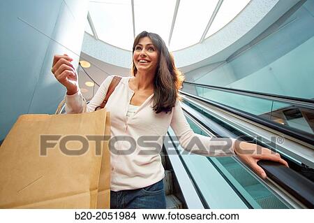Picture - 35 year old woman on escalators. Shopping at the Bretxa Market. Donostia. San Sebastian. Gipuzkoa. Basque Country. Spain.. Fotosearch