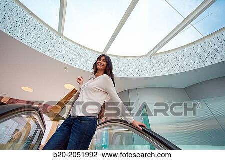 Stock Image - 35 year old woman on escalators. Shopping at the Bretxa Market. Donostia. San Sebastian. Gipuzkoa. Basque Country. Spain.. Fotosearch