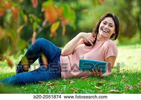 35 year old woman with digital tablet in park. Donostia. San Sebastian. Gipuzkoa. Basque Country, Spain. View Large Photo Image Picture - 35 year old woman with digital tablet in park. Donostia. San Sebastian. Gipuzkoa. Basque Country, Spain.. Fotosearch