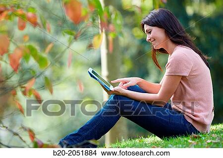 35 year old woman with digital tablet in park. Donostia. San Sebastian. Gipuzkoa. Basque Country, Spain. View Large Photo Image Picture - 35 year old woman with digital tablet in park. Donostia. San Sebastian. Gipuzkoa. Basque Country, Spain.. Fotosearch