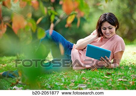 35 year old woman with digital tablet in park. Donostia. San Sebastian. Gipuzkoa. Basque Country, Spain. View Large Photo Image Stock Photo - 35 year old woman with digital tablet in park. Donostia. San Sebastian. Gipuzkoa. Basque Country, Spain.. Fotosearch
