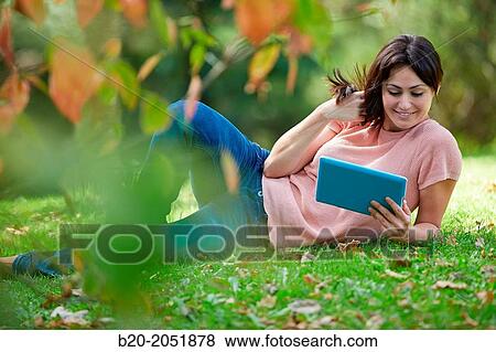 35 year old woman with digital tablet in park. Donostia. San Sebastian. Gipuzkoa. Basque Country, Spain. View Large Photo Image Stock Photo - 35 year old woman with digital tablet in park. Donostia. San Sebastian. Gipuzkoa. Basque Country, Spain.. Fotosearch
