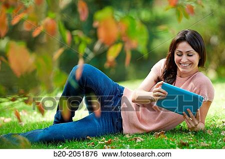 35 year old woman with digital tablet in park. Donostia. San Sebastian. Gipuzkoa. Basque Country, Spain. View Large Photo Image Stock Photograph - 35 year old woman with digital tablet in park. Donostia. San Sebastian. Gipuzkoa. Basque Country, Spain.. Fotosearch