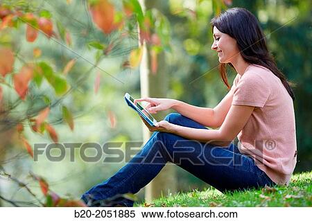 35 year old woman with digital tablet in park. Donostia. San Sebastian. Gipuzkoa. Basque Country, Spain. View Large Photo Image Stock Photography - 35 year old woman with digital tablet in park. Donostia. San Sebastian. Gipuzkoa. Basque Country, Spain.. Fotosearch