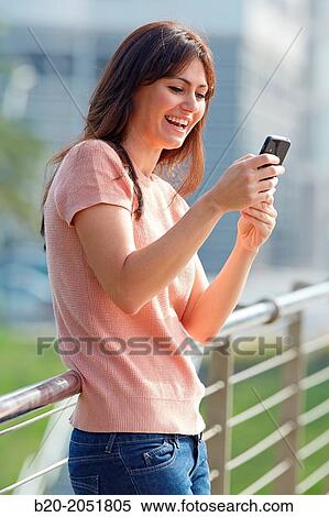 Stock Photography - 35 year old woman with smartphone in town. Donostia. San Sebastian. Gipuzkoa. Basque Country, Spain.. Fotosearch
