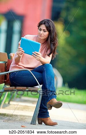 Picture - 35 year old woman with tablet in a park. Donostia. San Sebastian. Gipuzkoa. Basque Country, Spain.. Fotosearch