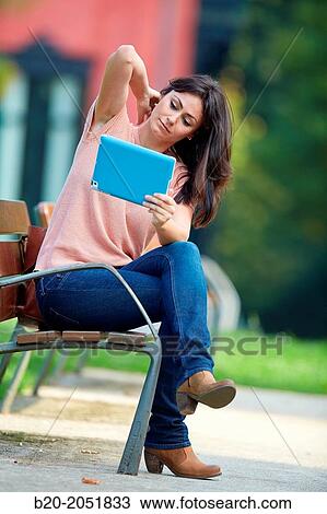 Stock Image - 35 year old woman with tablet in a park. Donostia. San Sebastian. Gipuzkoa. Basque Country, Spain.. Fotosearch