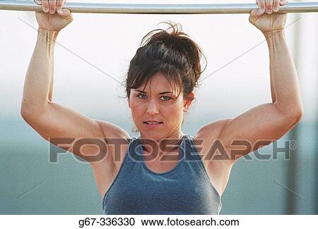 Stock Image - 35 years old woman flexes muscles on the beach. Santa Monica. California. USA.. Fotosearch