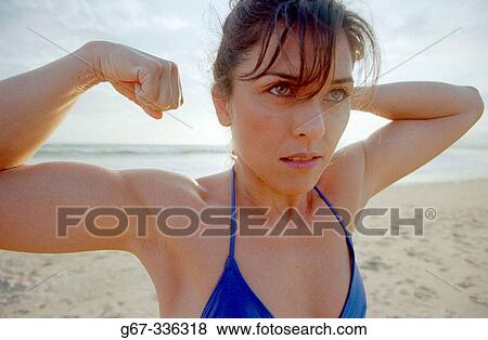 Stock Photo - 35 years old woman flexes muscles on the beach. Santa Monica. California. USA.. Fotosearch