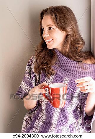 37 year old brunette woman wearing a big sweater and holding a cup of steaming tea in a kitchen setting. View Large Photo Image Stock Image - 37 year old brunette woman wearing a big sweater and holding a cup of steaming tea in a kitchen setting.. Fotosearch