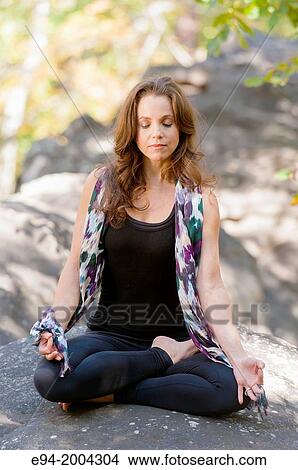 37 year old brunette woman wearing fitness clothes doing a yoga pose in a forest setting. View Large Photo Image Picture - 37 year old brunette woman wearing fitness clothes doing a yoga pose in a forest setting.. Fotosearch