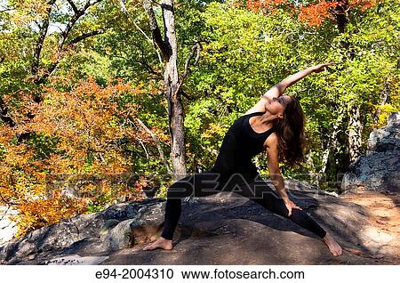 37 year old brunette woman wearing fitness clothes doing a yoga pose in a forest setting. View Large Photo Image Stock Image - 37 year old brunette woman wearing fitness clothes doing a yoga pose in a forest setting.. Fotosearch