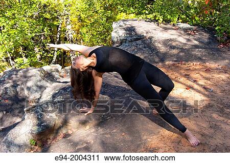 37 year old brunette woman wearing fitness clothes doing a yoga pose in a forest setting. View Large Photo Image Stock Image - 37 year old brunette woman wearing fitness clothes doing a yoga pose in a forest setting.. Fotosearch