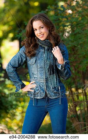 Stock Photo - 37 year old brunette woman wearing casual clothes outdoors in the autumn smiling at the camera.. Fotosearch
