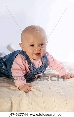 4 month old baby girl, smiling off camera, lying on her tummy View Large Photo Image Picture - 4 month old baby girl, smiling off camera, lying on her tummy. Fotosearch