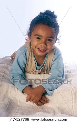 4 year old, black girl smiling into camera lying on her tummy View Large Photo Image Stock Photo - 4 year old, black girl smiling into camera lying on her tummy. Fotosearch