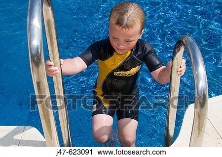 4 year old boy climbing out of the swimming pool; outside, wearing a wetsuit View Large Photo Image Stock Image - 4 year old boy climbing out of the swimming pool; outside, wearing a wetsuit. Fotosearch