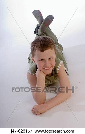 4 year old boy lying on his tummy smiling into camera View Large Photo Image Stock Photo - 4 year old boy lying on his tummy smiling into camera. Fotosearch