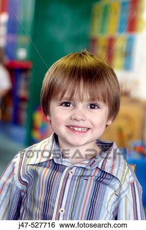 Stock Photograph - 4 year old boy smiling into camera at nursery. Fotosearch